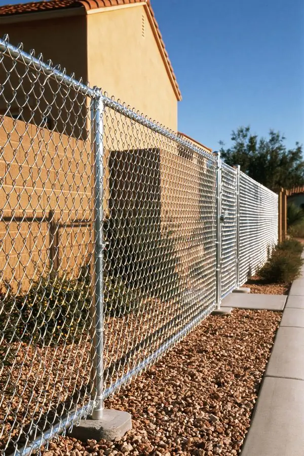 Chain link fence in Tempe, AZ running taut and level along a gravel side yard