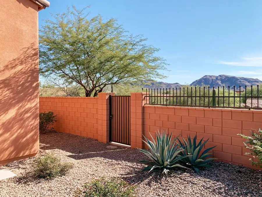 Block wall and wrought iron gate at the entry of a well-kept Tempe, AZ home with desert landscaping