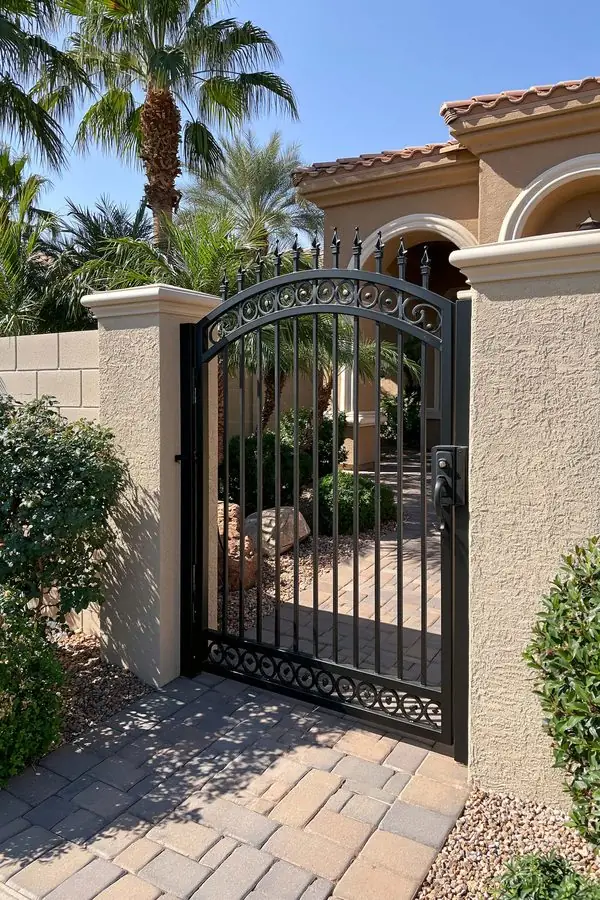 Wrought iron courtyard gate hanging square between stucco pillars after gate repair in Tempe, AZ